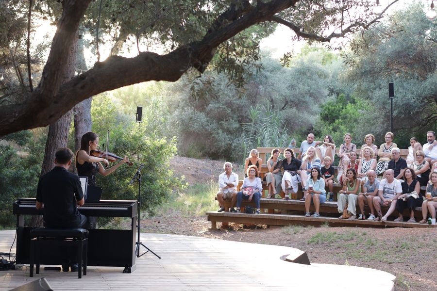 Música en vivo de violín y piano al atardecer en el auditorio natural de Bosque.